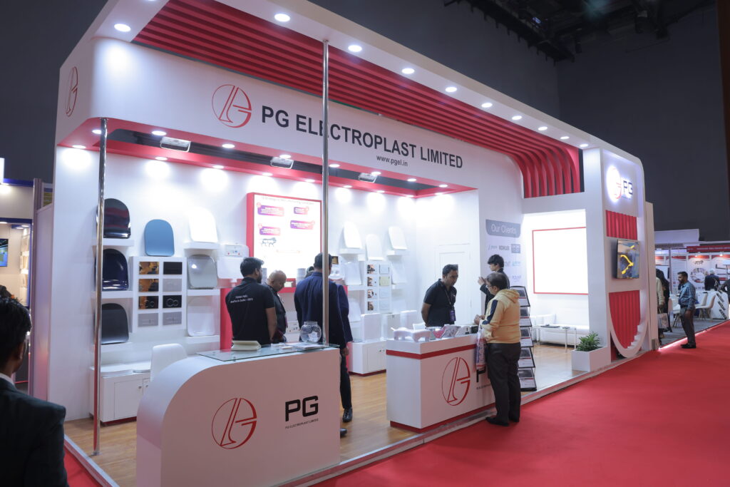 Exhibition stall design company in Delhi NCR creating a high-impact exhibition booth with bold red branding, modern lighting, and structured product display for maximum visibility
